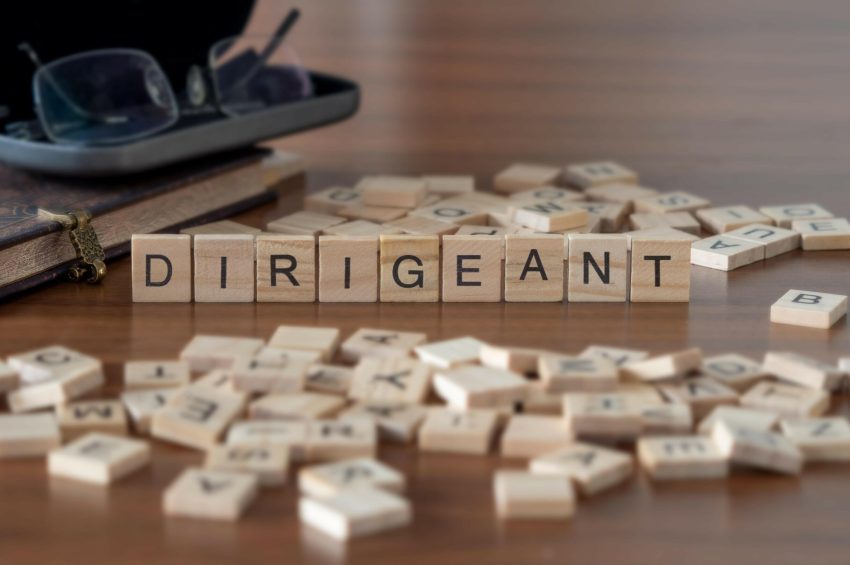 dirigeant mot ou concept représenté par des carreaux de lettres en bois sur une table en bois avec des lunettes et un livre